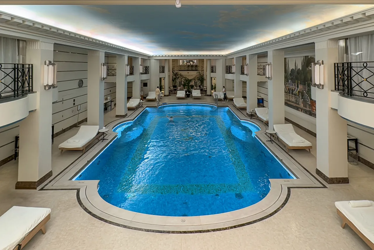 La piscine intérieure du Ritz Paris, son bassin bleu entouré de colonnes et de chaises longues