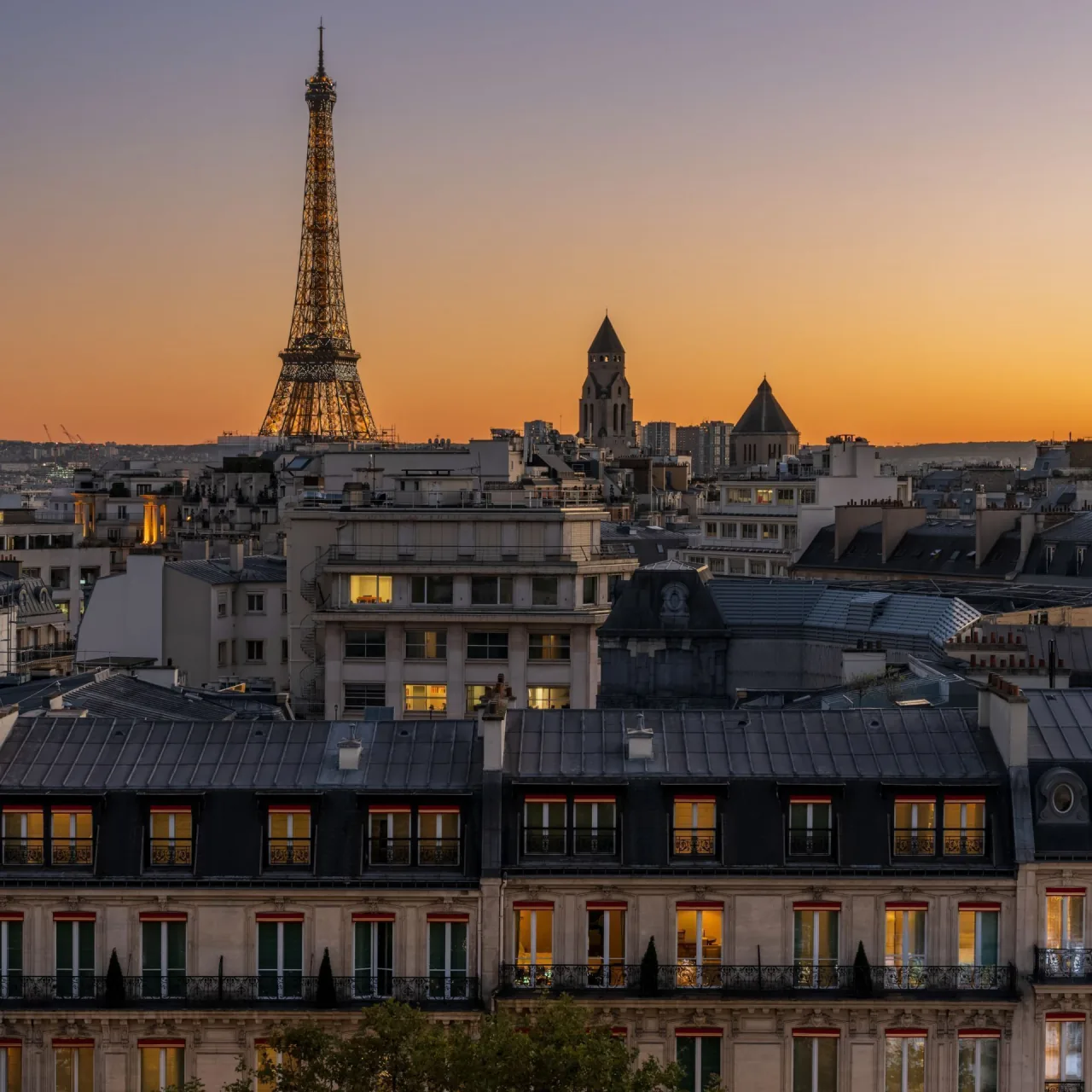 La tour Eiffel et un dôme au crépuscule, au-dessus des toits de Paris