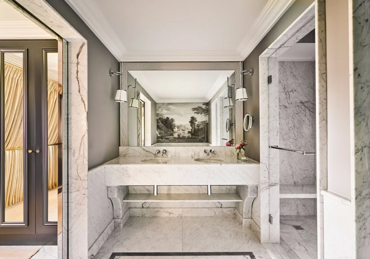Une salle de bains en marbre blanc, une double vasque sous un panneau de paysage peint