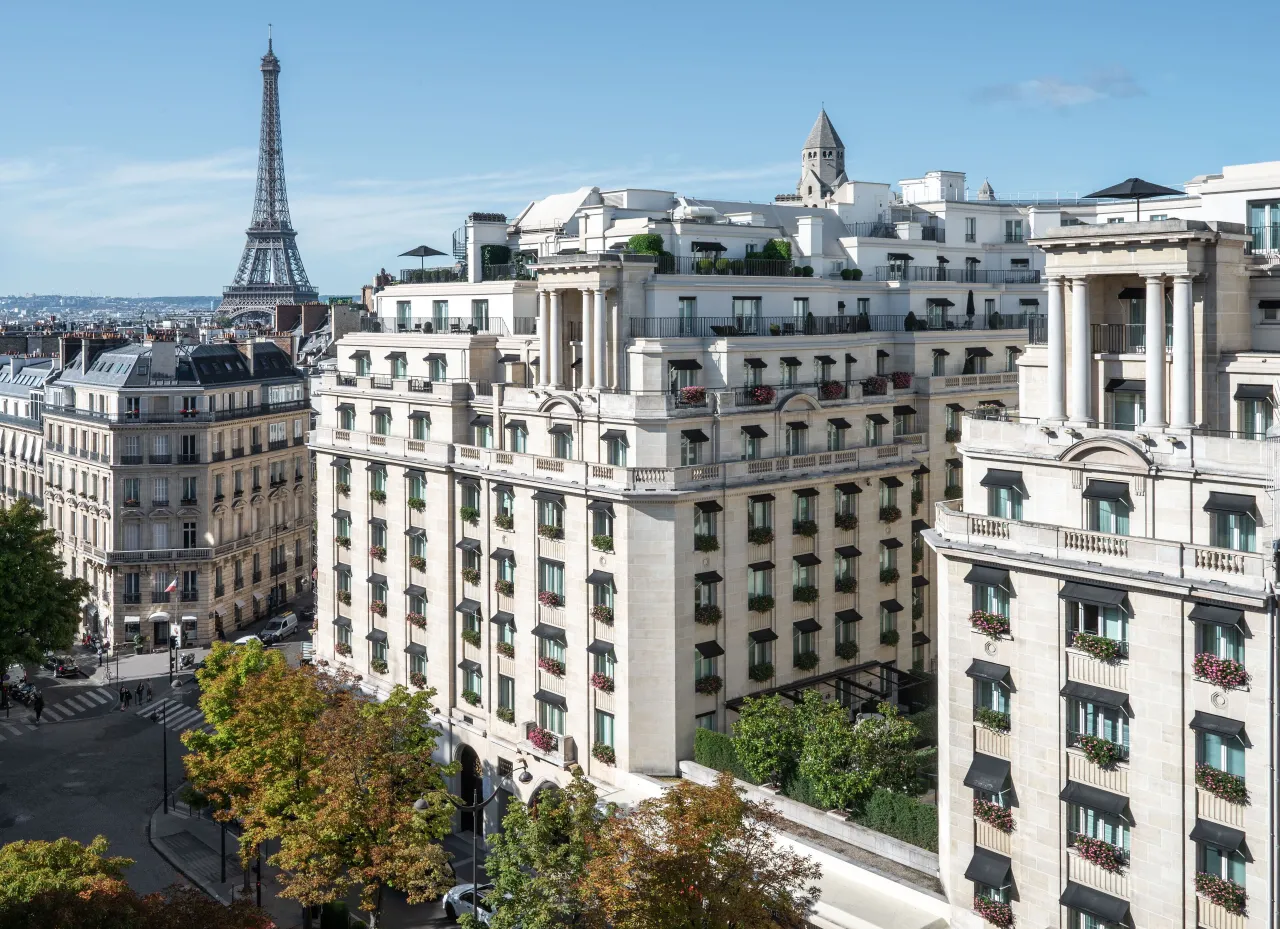 Les bâtiments de pierre blanche de l’hôtel vus d’en haut, la tour Eiffel au loin