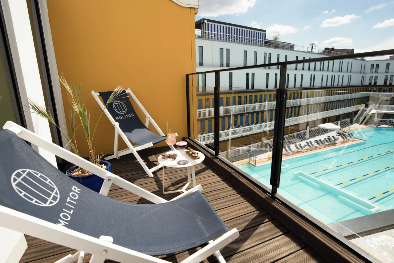 Un balcon et deux transats au-dessus du bassin extérieur